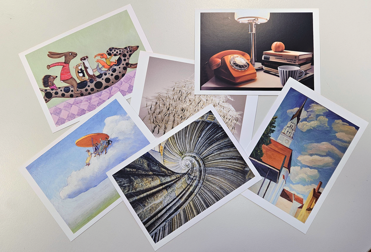 Postkarten mit Kunstmotiven auf einem Tisch ausgebreitet