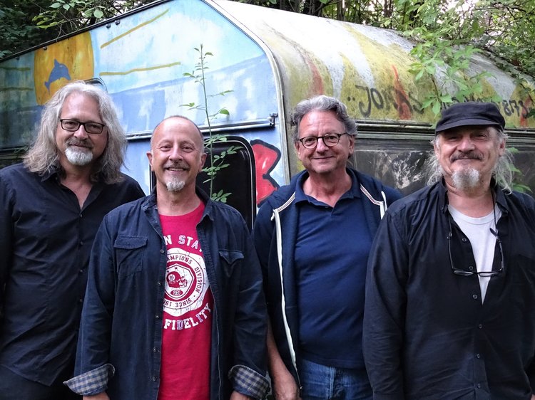 Günther Grünwald und Rad Gumbo posieren vor einem alten Wohnwagen