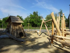Spielplatz auf Sand mit Holz-Spielgeräten