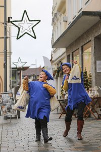 Zwei WIchtel mit Säcken in der Stadt unterwegs
