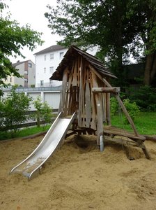 Spielplatz mit Kletterturm und Rutsche auf Sand