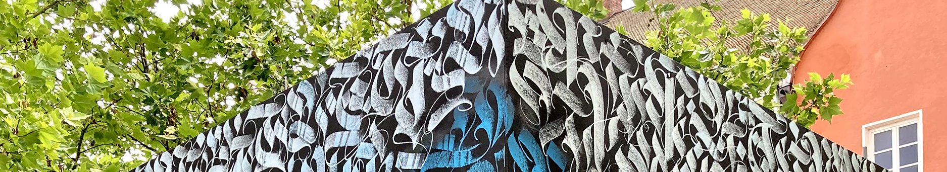 Graffiti-Kunstwerk spitze des bemalten Würfels mit Bäumen und Hausgiebel
