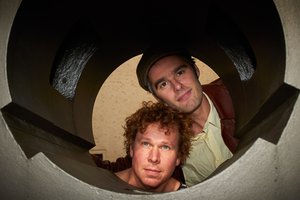 Die beiden Darsteller schauen durch einen Tunnel.