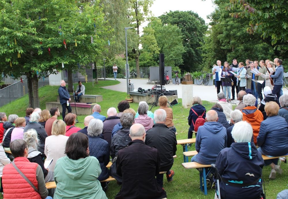 Menschen im Bürgerpark auf Bänken beim Friedensgebet
