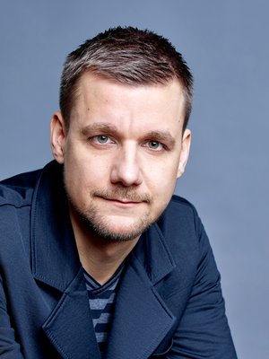 Portraits des Autors vor einer blauen Wand.