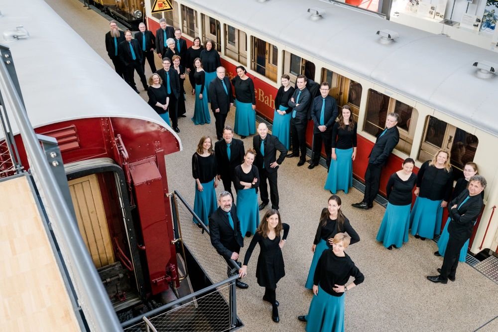 Chor am Bahnsteig, von oben forografiert, alle tragen blau-schwarze Kleidung