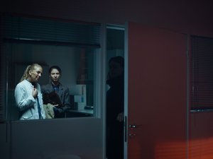 Ärztin steht mit zwei Frauen vor einem Patientenzimmer.